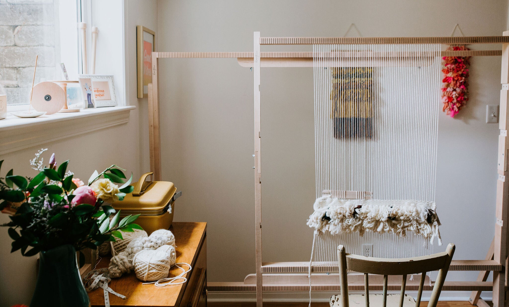 Room with a wooden crib, flowers, and a window sill with decor.